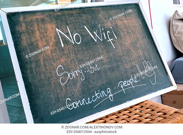 No Wi Fi sign. Sorry, but connecting people - chalk text written on blackboard at restaurant. Talk to each other concept