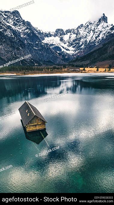 Traditional wooden boathouse reflecting on the crystal clear water of the Almsee, near Grünau im Almtal, Oberösterreich, Austria