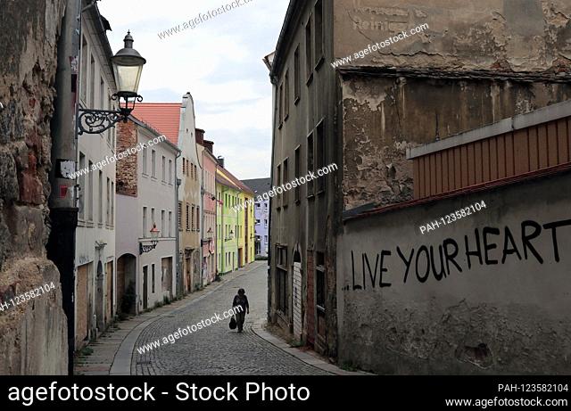 View of a partially renovated street in the old town of Zittau in the far south-east of Saxony on August 20, 2019. Dilapidated old buildings and ruins stand...
