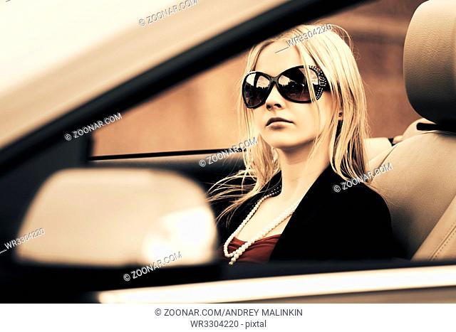 Young fashion woman driving convertible car