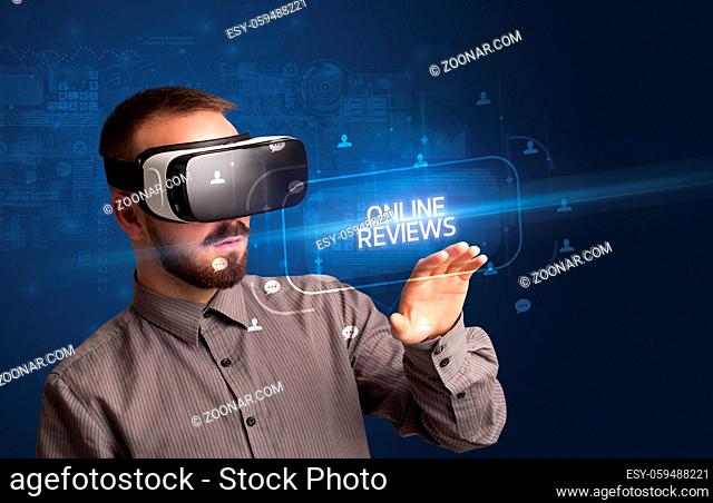 Businessman looking through Virtual Reality glasses with ONLINE REVIEWS inscription, social networking concept