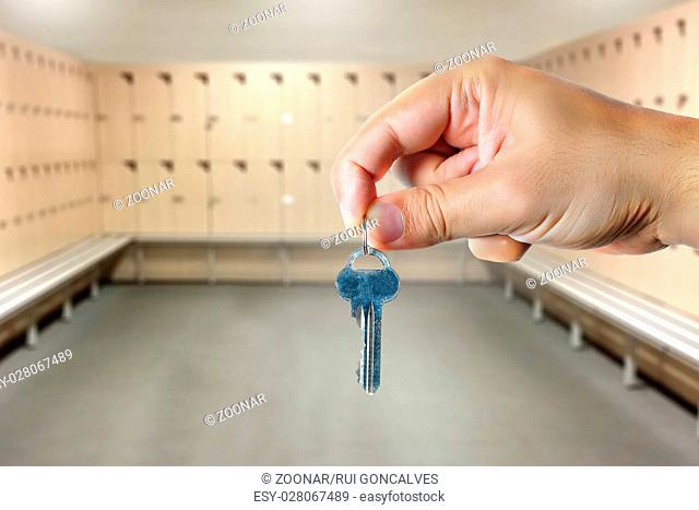 Hand Holding a Key in a Locker Room
