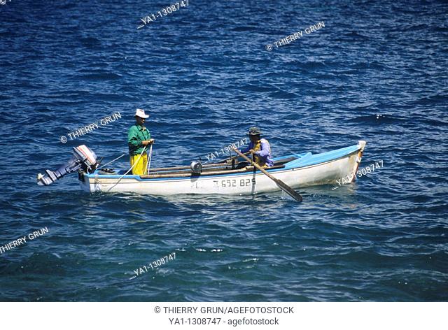 Local fishermen fishing with small boat, Anse des cascades (between Piton Sainte Rose and Bois Blanc), La Reunion island (France), Indian Ocean