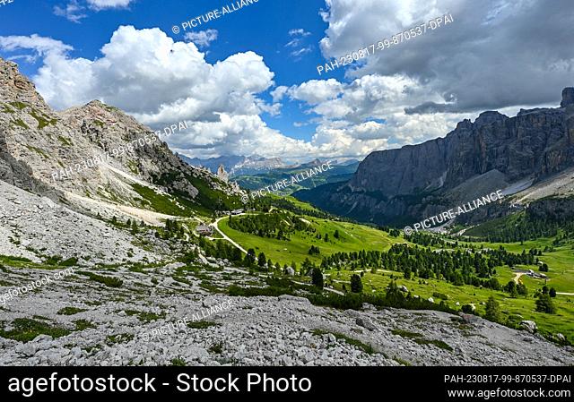 20 July 2023, Italy, Wolkenstein: Hiking area at the peaks of the Cirspitzen (l) with the Jimmi Hut (M) and the peaks of the Sella Group (r) in the Dolomites in...