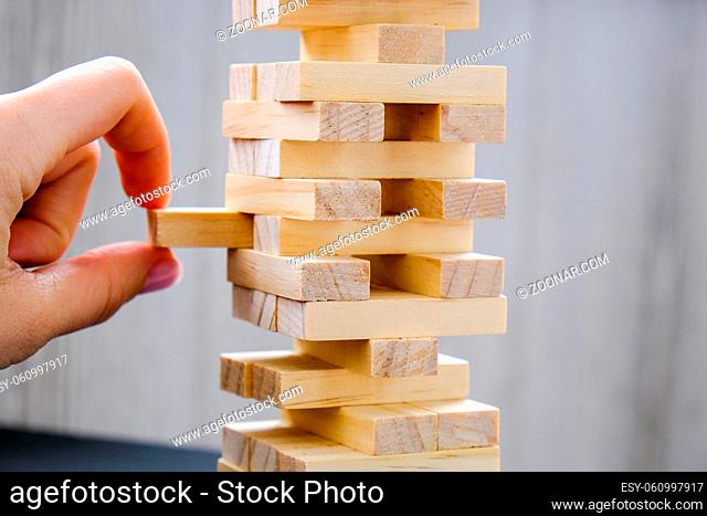 Building from wooden blocks. Wood blocks stack game with Hand on background. Conceptual of Teamwork. Block tower with architecture model