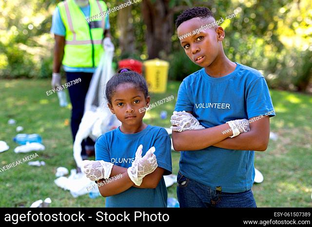 Portrait of a mixed race boy and girl collecting garbage
