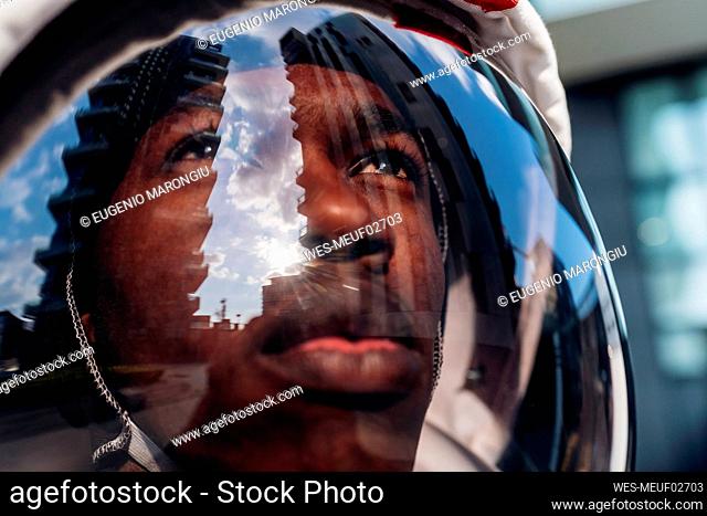 Male astronaut wearing space helmet looking up