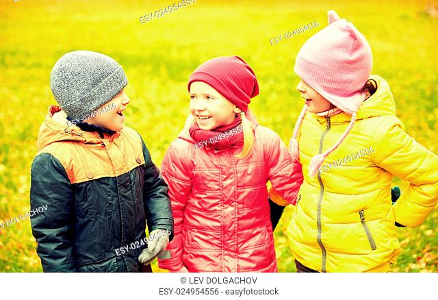 childhood, leisure, friendship and people concept - group of happy children in autumn park