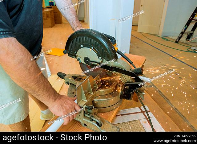 Craftsman sawing metal with disk grinder in sparks while grinding iron