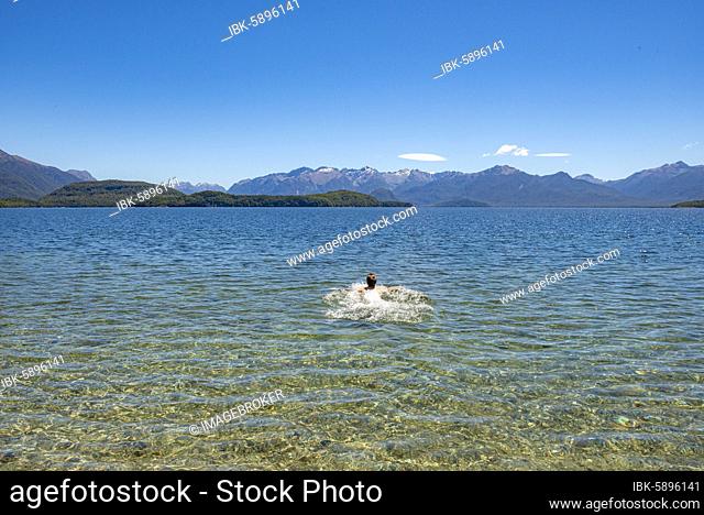 Young man bathes in the lake, Lake Manapouri, Frasers Beach, Manapouri, South Island, New Zealand, Oceania