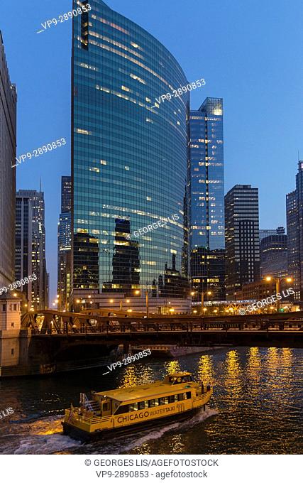 225 and 333 West Wacker drive buildings and boat on Chicago river at night. Chicago, Illinois, USA