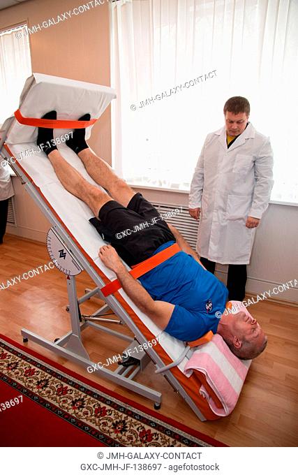 At his Cosmonaut Hotel crew quarters in Baikonur, Kazakhstan, Expedition 3940 Flight Engineer Steve Swanson of NASA takes a turn on a tilt table March 19 as...