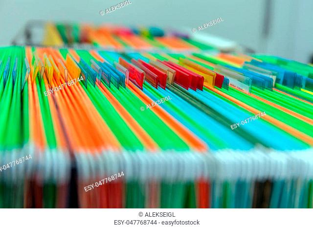 Abstract background of colorful hanging file folders in drawer. Stock photo