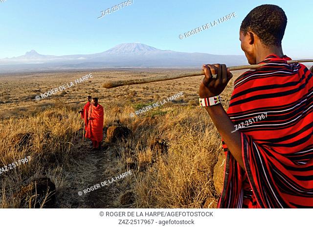 Maasai (Masai) elders with Mount (Mt) Kilimanjaro and Mount (MT) Mawenzi (in Tanzania) on the left in the background. Satao Elerai Conservancy