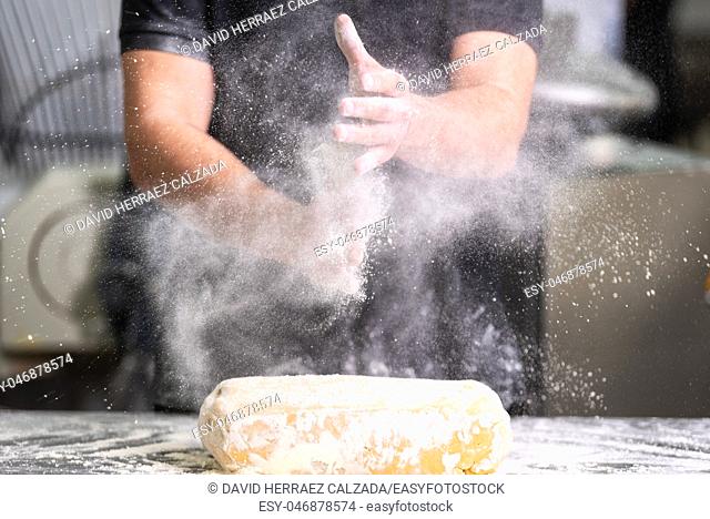 Pastry Chef clapping his hands with flour while making dough