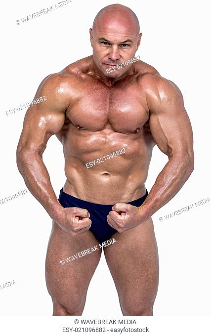 Portrait of shirtless bodybuilder flexing muscles