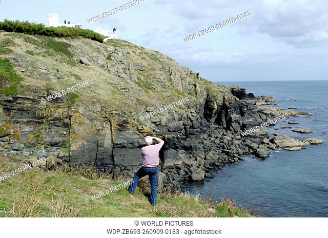 man photographing Lizard Lighthouse and coast Lizard Point The Lizard Cornwall England