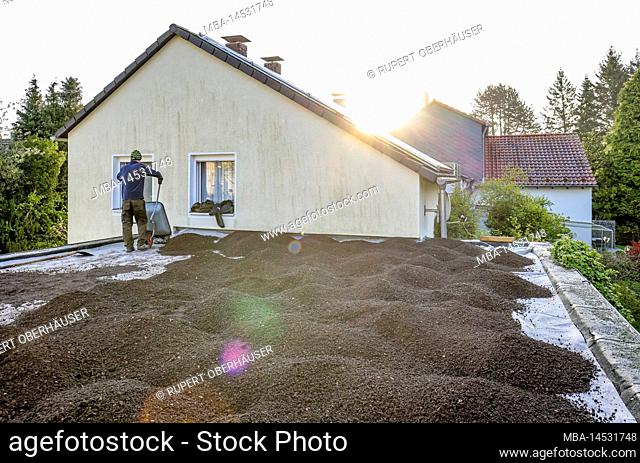 Mülheim an der Ruhr, North Rhine-Westphalia, Germany, flat roof is prepared for green roof. Here, the substrate layer is applied to the separating fleece to the...