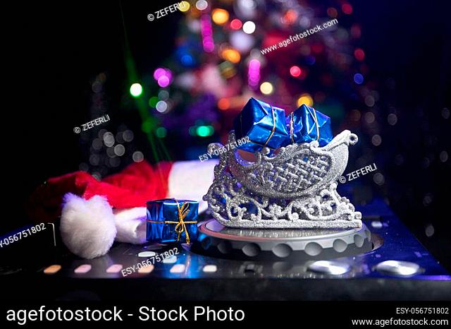 Dj mixer with headphones on dark nightclub background with Christmas tree New Year Eve. Close up view of New Year elements on a Dj table