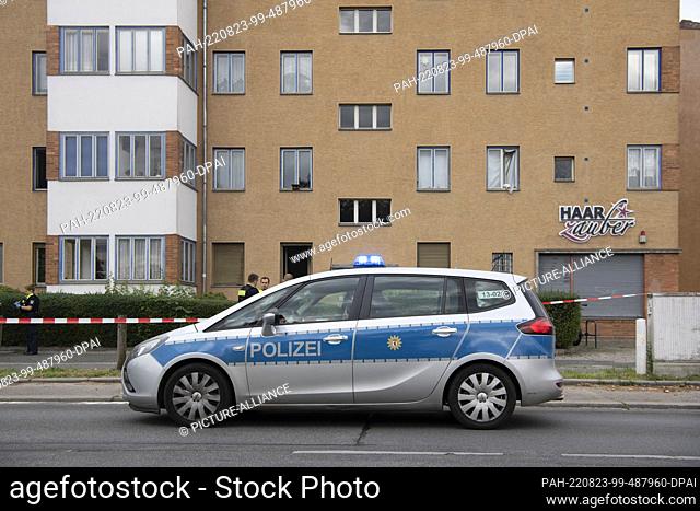 23 August 2022, Berlin: A police emergency vehicle stands at the intersection of Kissingenstraße and Prenzlauer Promenade in front of a residential building