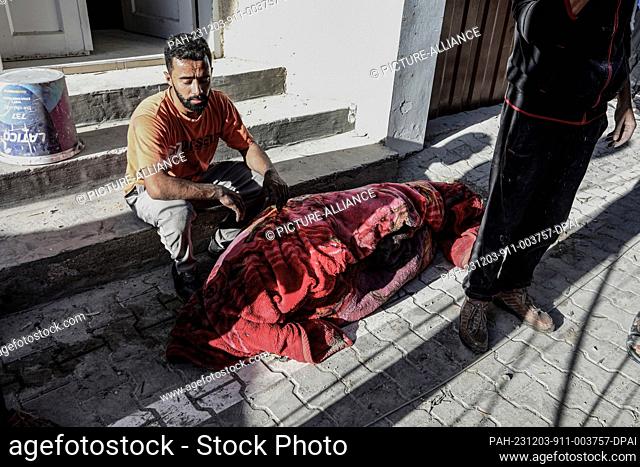 03 December 2023, Palestinian Territories, Rafah: Palestinians grieve their relatives and loved ones murdered in an Israeli air strike on the Azoum family's...