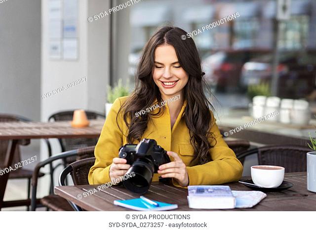 tourist or teenage girl with camera at city cafe