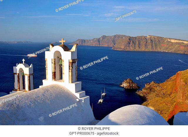 CHURCH IN THE VILLAGE OF OIA ON THE ISLAND OF SANTORINI, IN THE BACKGROUND THE ISLAND OF THIRASSIA, CYCLADES, GREECE