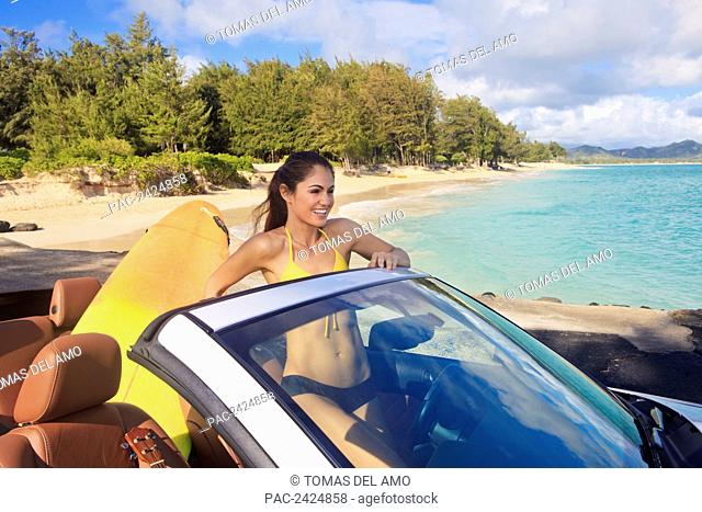 Hawaii, Oahu, Kailua Beach, Beautiful woman smiles as she arrives at the beach in her convertible