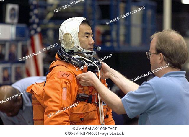 Astronaut Soichi Noguchi, STS-114 mission specialist representing the Japan Aerospace Exploration Agency (JAXA), dons a training version of the shuttle launch...