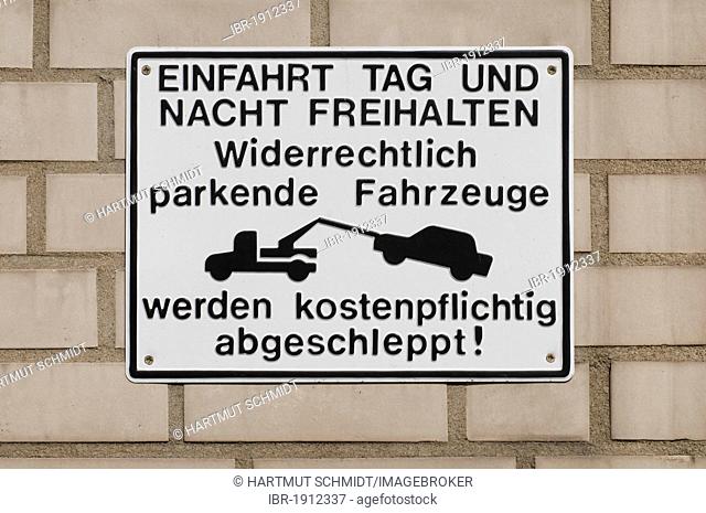 Sing on wall with tow truck pictogram, Einfahrt Tag und Nacht freihalten, widerrechtlich geparkte Fahrzeuge werden kostenpflichtig abgeschleppt