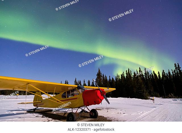 Plane beneath the aurora borealis at the Delta Junction airstrip; Alaska, United States of America