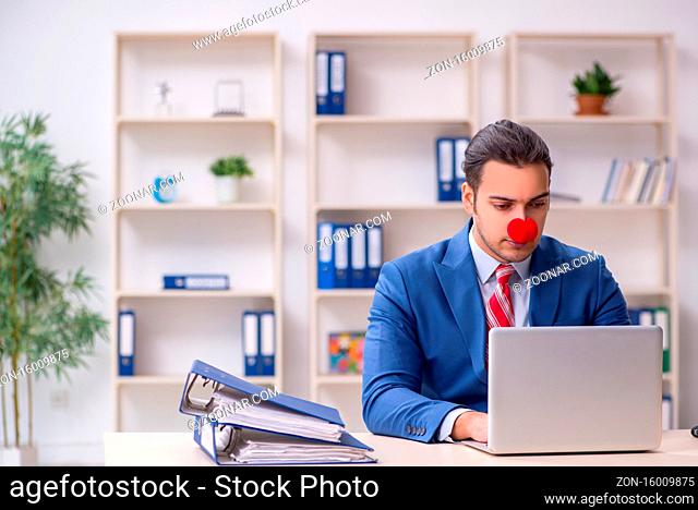 Funny employee clown working in the office room