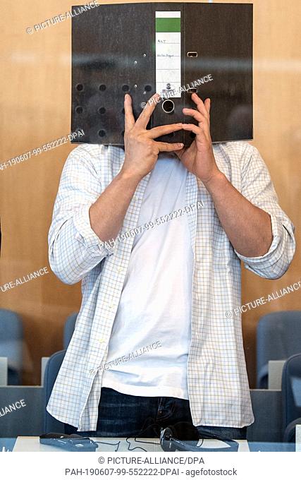 07 June 2019, North Rhine-Westphalia, Duesseldorf: The defendant is holding a file in front of his face. The trial against the alleged Islamic ricin bomb...