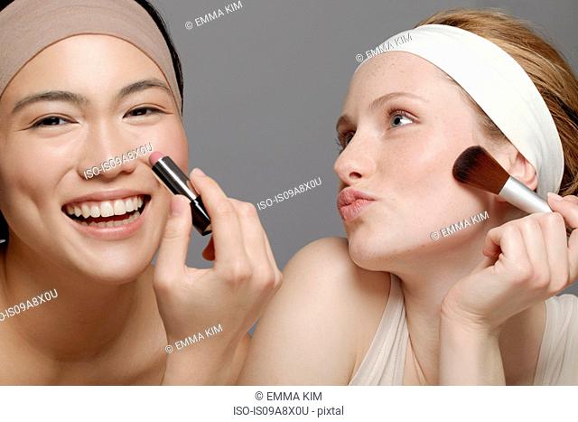 Young women putting on make up