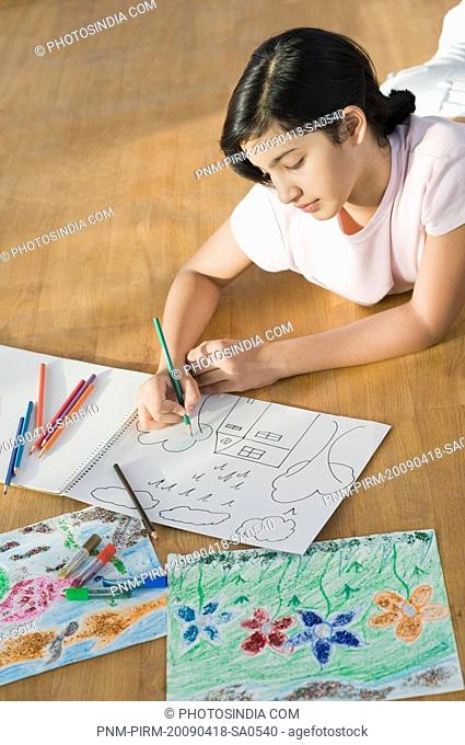 Girl lying on the floor and making a drawing