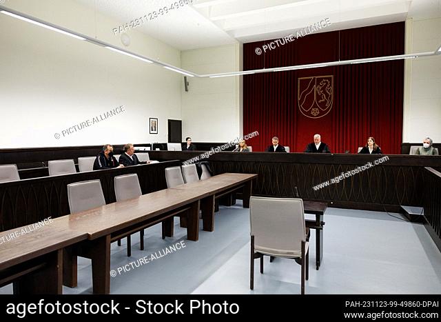 23 November 2023, North Rhine-Westphalia, Paderborn: Wilfried W. (left) sits next to his defense lawyer Carsten Ernst (2nd from left) in a courtroom at...