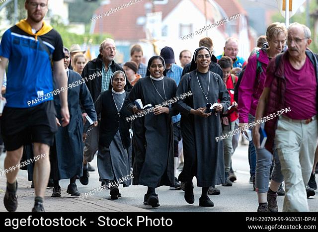 09 July 2022, Lower Saxony, Bad Iburg: Pilgrims of the 170th foot pilgrimage from Osnabrück to Telgte walk on a road. For the first time after the Corona break