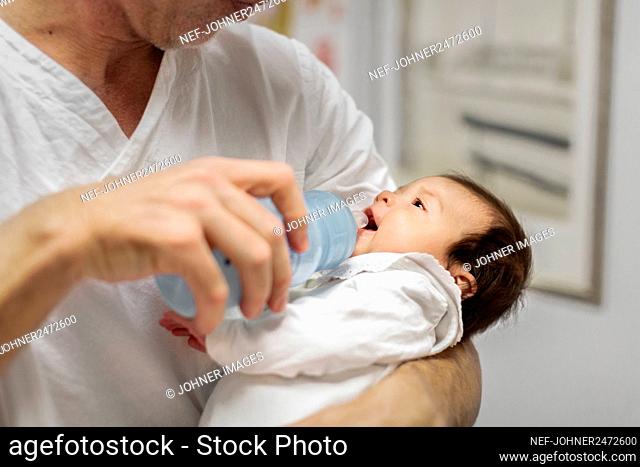 Doctor feeding newborn baby