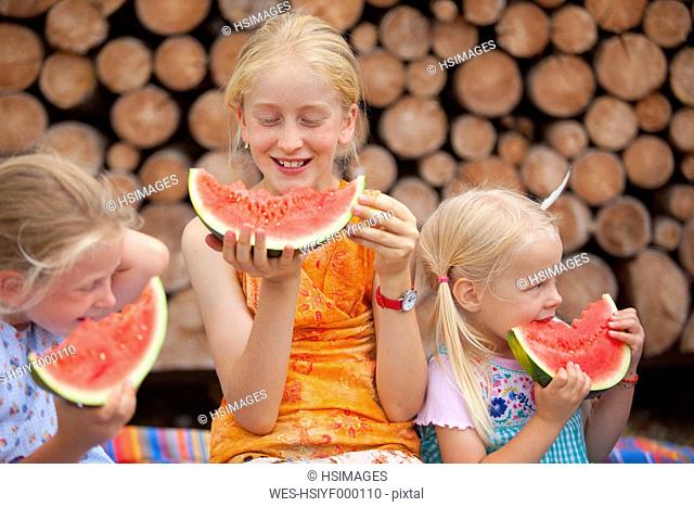 Germany, Bavaria, Girls eating watermelon