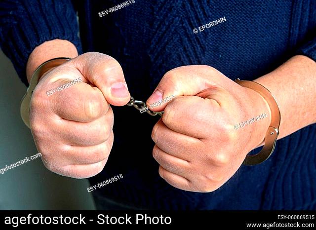 Men's hands in handcuffs close up. High quality photo