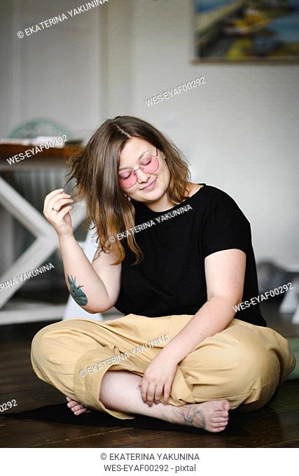 Portrait of tattooed woman sitting on the floor at home