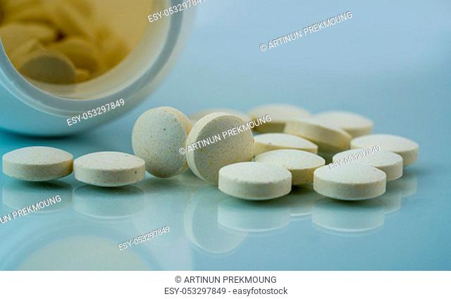 Vitamins, minerals and supplements tablets pills with open plastic bottle on white background. Zinc amino acid chelate dietary supplement product