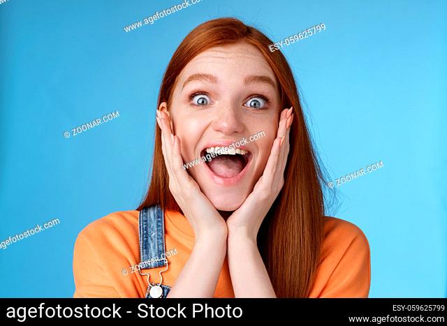Impressed excited overwhelmed young redhead girlfriend fan screaming thrilled express afection adore awesome music band yelling happily reacting surprised...