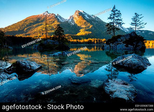 Fantastic sunrise at Hintersee lake. Beautiful scene of trees on a rock island during Spring in Berchtesgaden Germany