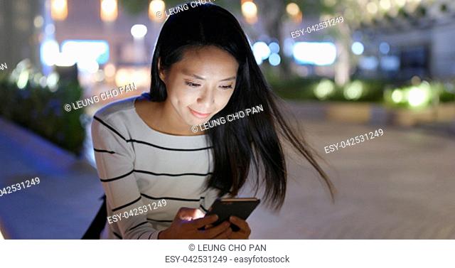 Woman looking at smart phone in city