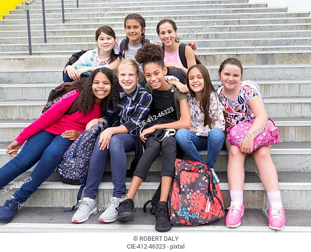 Portrait confident junior high girl students on steps