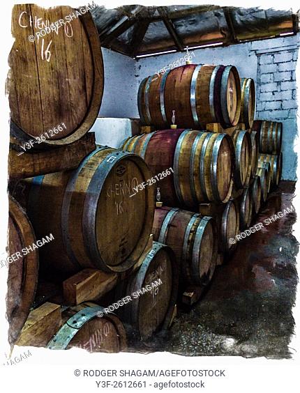 Wine maturing in barrels in a wine cellar. Grunge with border. Western Cape Province, South Africa
