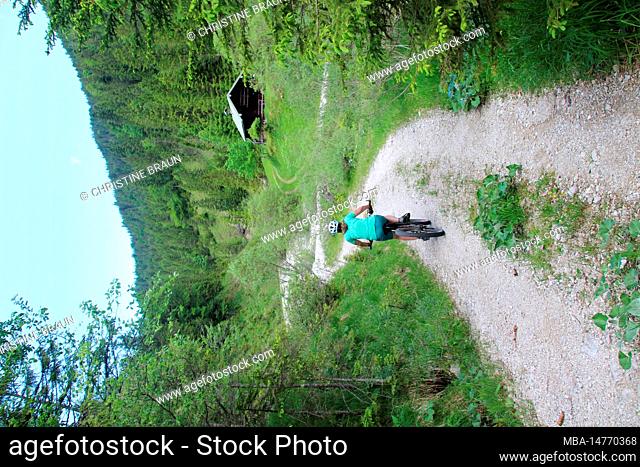 Woman on e-bike, cyclist, hunting lodge in Fischbachtal, hiking trail, summer, Alpenwelt Karwendel, Krün, Germany, Bavaria, Upper Bavaria