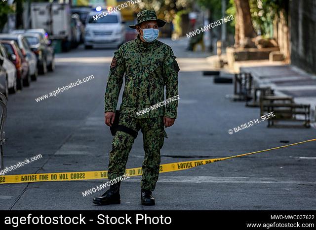 A policeman wearing a protective mask stands guard at a checkpoint in Barangay Kalusugan, Quezon City after the area behind St