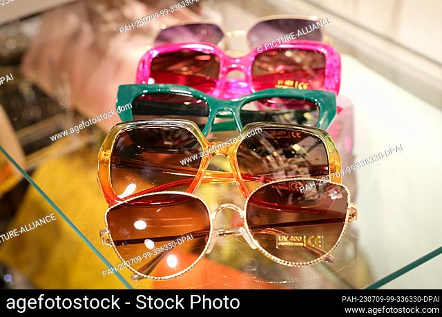 PRODUCTION - 05 July 2023, Hamburg: Colorful and fancy sunglasses lie on the glass table of a fashion store. (to dpa Top or Flop? - Five fashion sins in the...